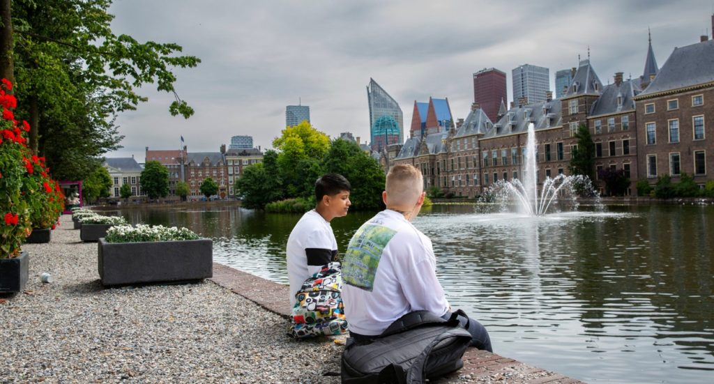 2 dakloze jongeren zittend op de rand van de Hofvijver.