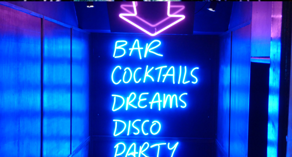 neon signs saying bar, cocktails, dreams disco party